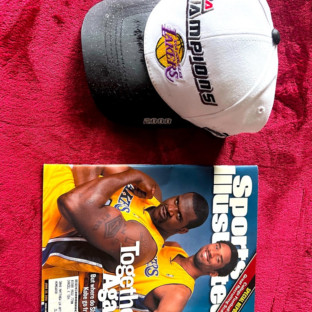 Lakers hat and magazine. Hat is new in box but has smudge on lid as pictured.